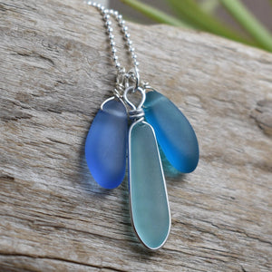 Blue sea glass necklace on a wooden surface